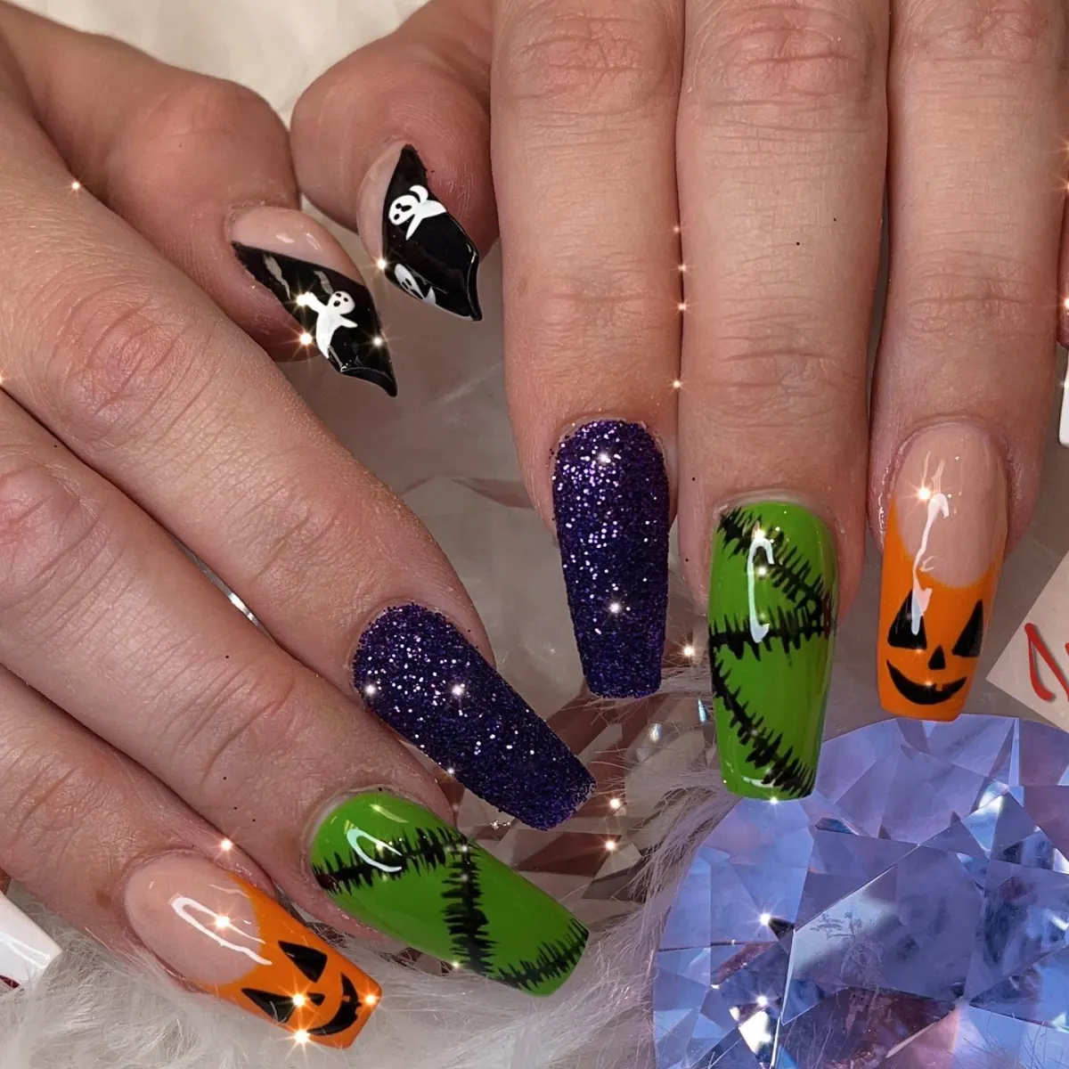 Mixed Halloween nail colors with black, purple, orange, and green polish